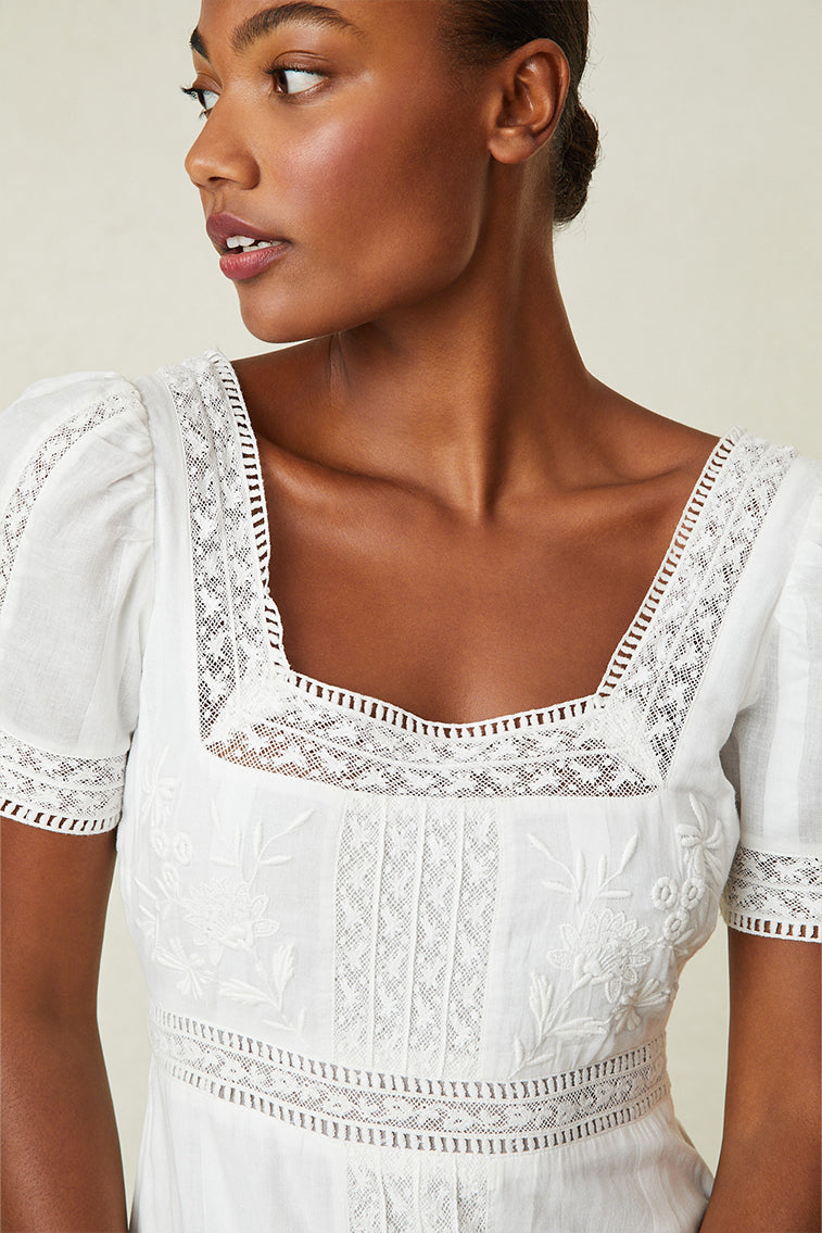 White Victorian maxi dress neckline detail with embroidered trim and short puff sleeves