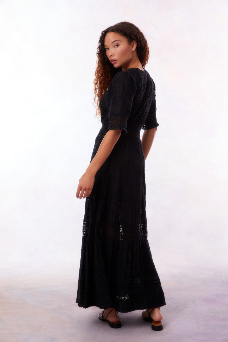 Black maxi dress back view with three-quarter sleeves and flowing tiered skirt