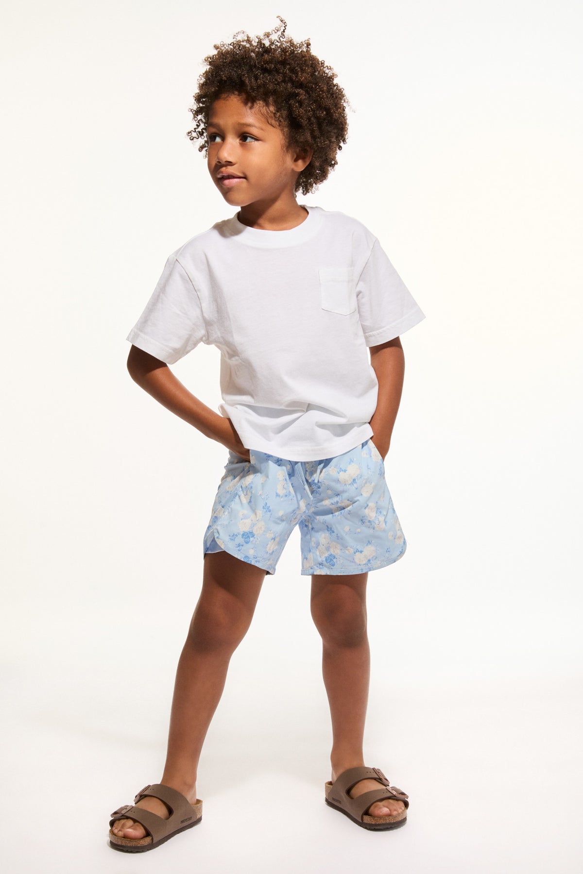 Light blue patterned boys swim shorts with elastic waist and drawstring.