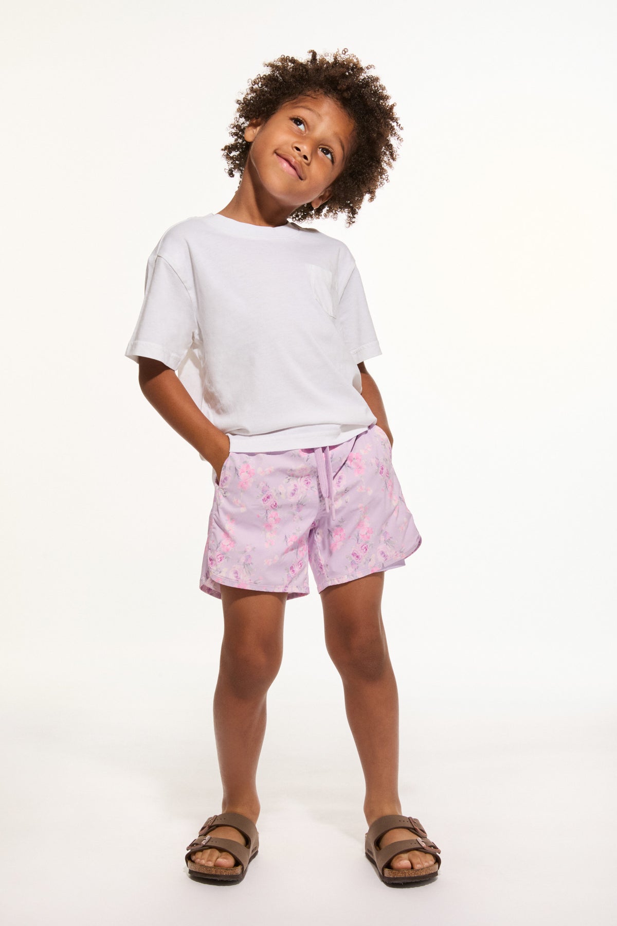 Pink patterned boys swim shorts with elastic waist and drawstring.