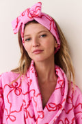 Pink bow print headband with top knot bow, worn close-up
