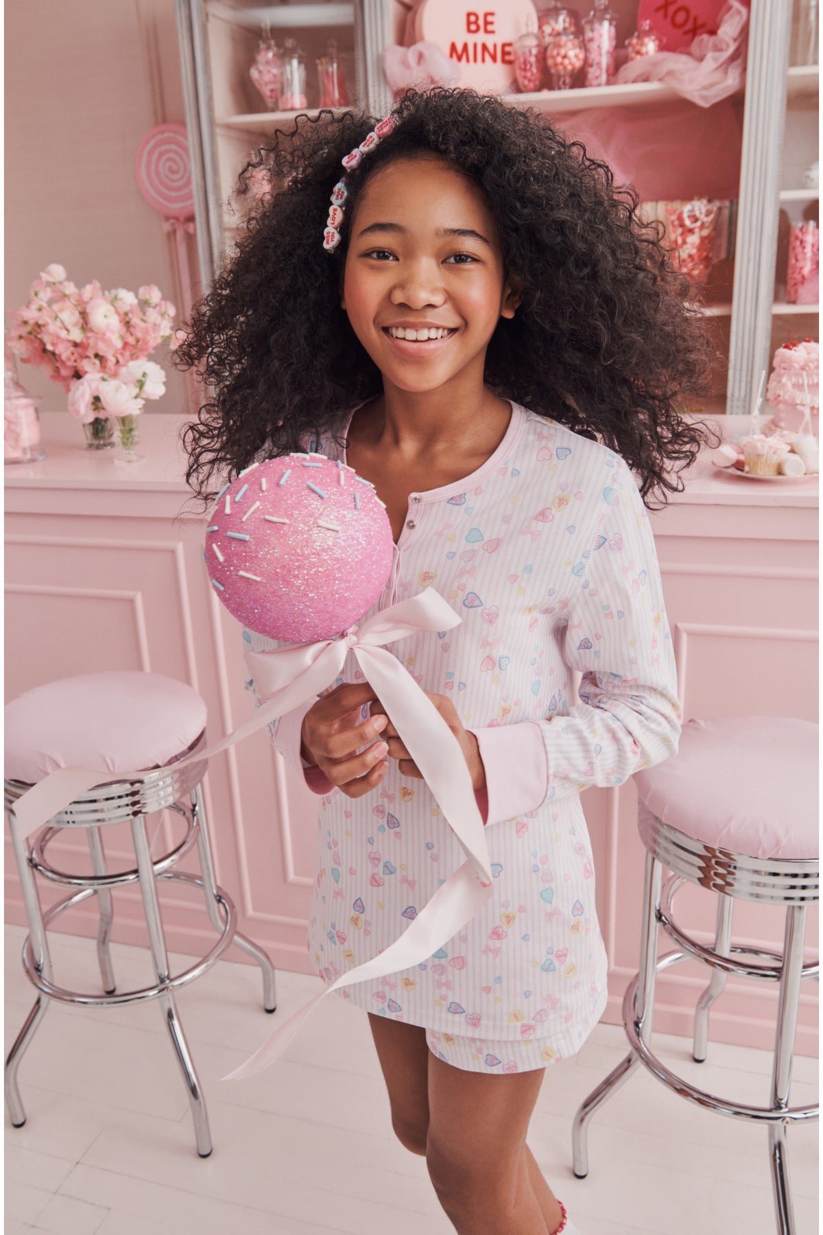 Girls' long-sleeve pajama shirt and shorts with pastel heart print, smiling