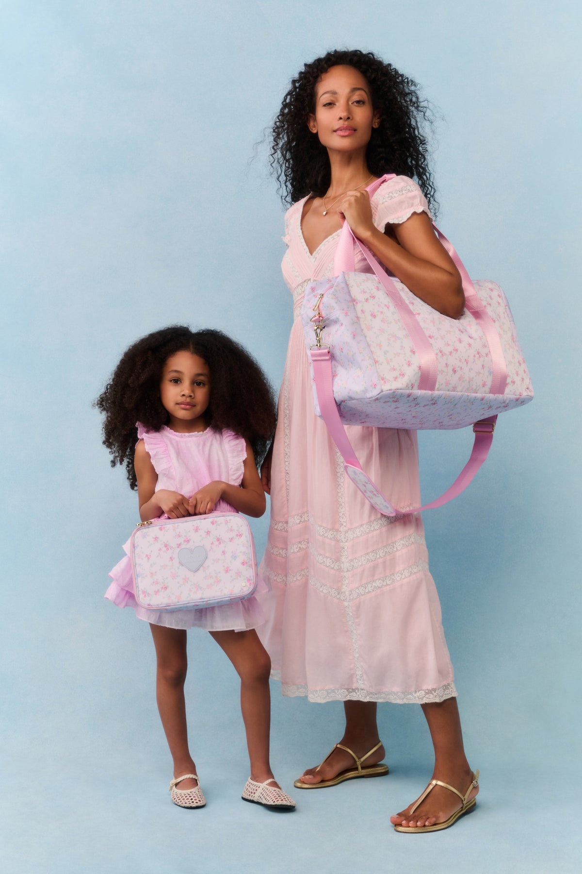 Floral duffel set with pink straps and heart emblem, two matching bags