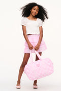 Pink quilted duffle bag with ribbon handles and heart pattern