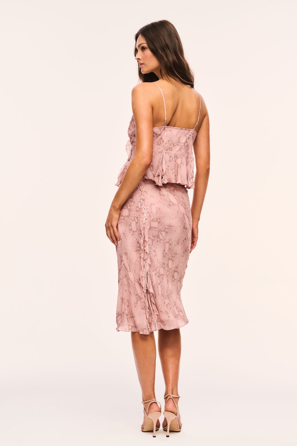 Pink snakeskin print midi skirt from back view with ruffle hem
