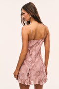 Back view of pink snakeskin-print mini dress with thin straps and ruffled hem