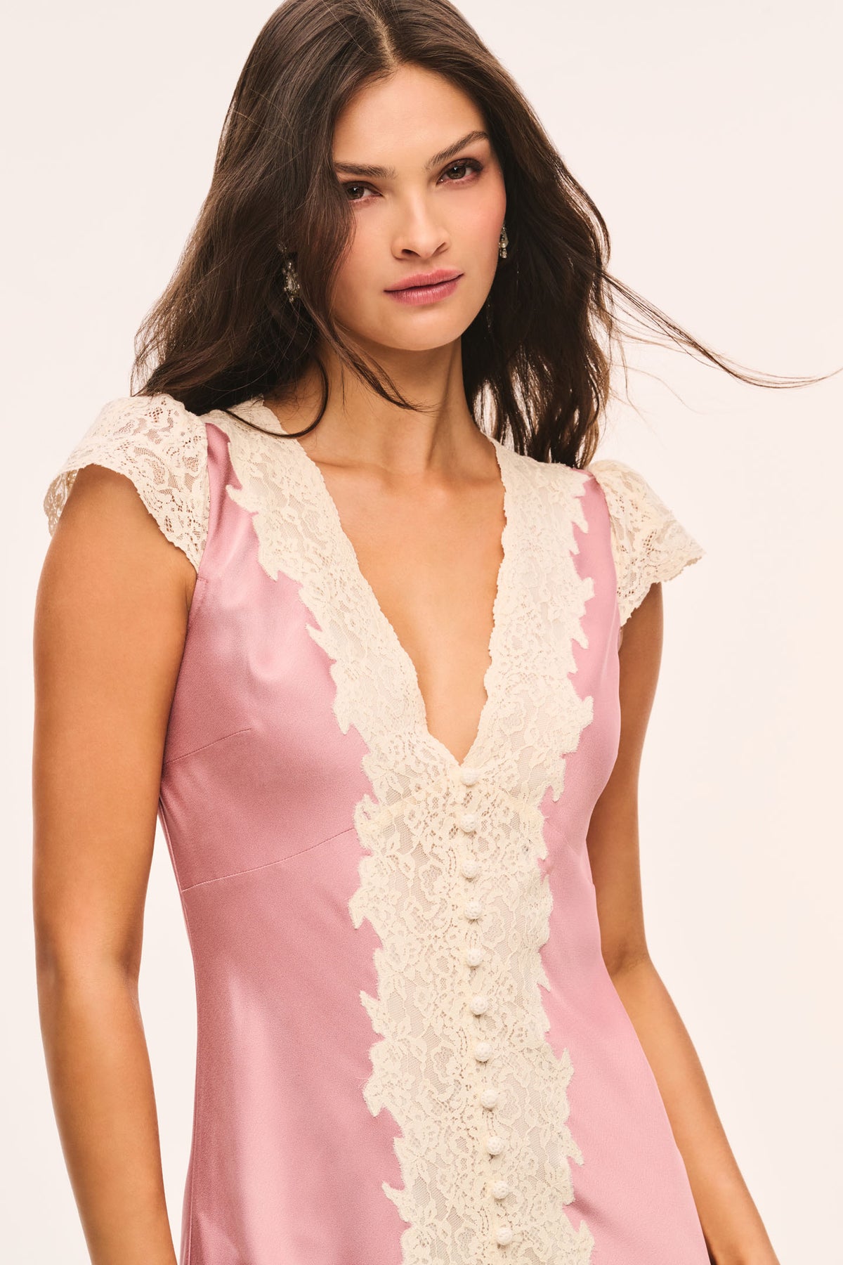 Pink satin midi dress close-up with cream lace V-neck and cap sleeves