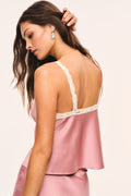 Pink satin cami with cream lace racerback trim along the open back