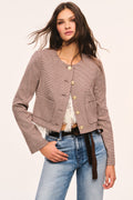 Brown and beige cropped checkered jacket front view: gold-tone button front and patch pockets styled with a cream lace top and jeans