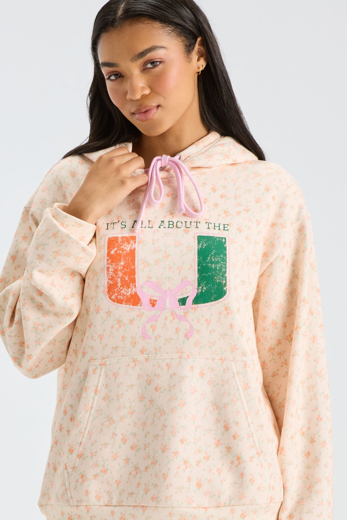 Light peach hoodie close-up with kangaroo pocket and multicolor 'LC' graphic