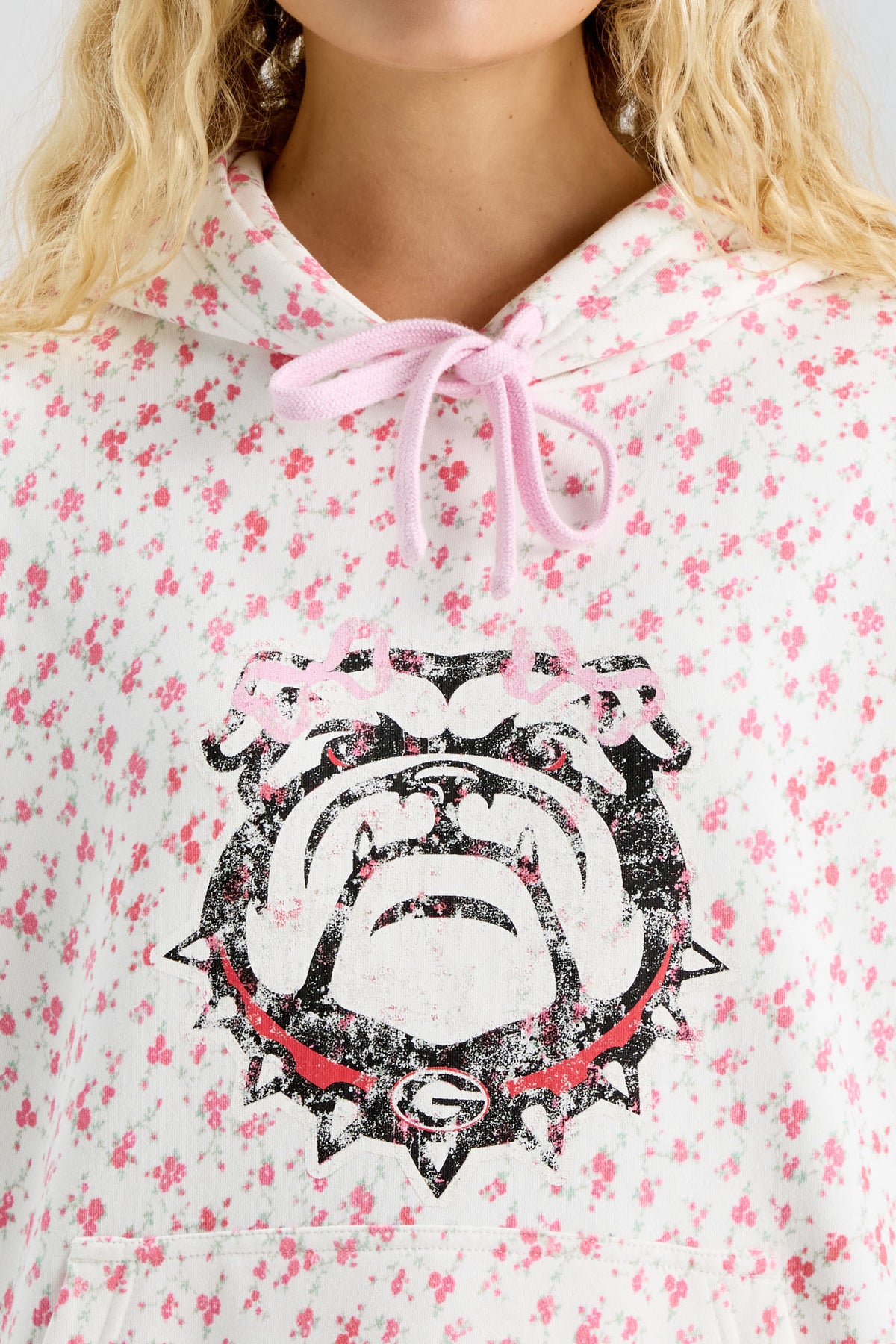 Pink floral-print hoodie with hood tie ribbon and bold Texas longhorn logo graphic