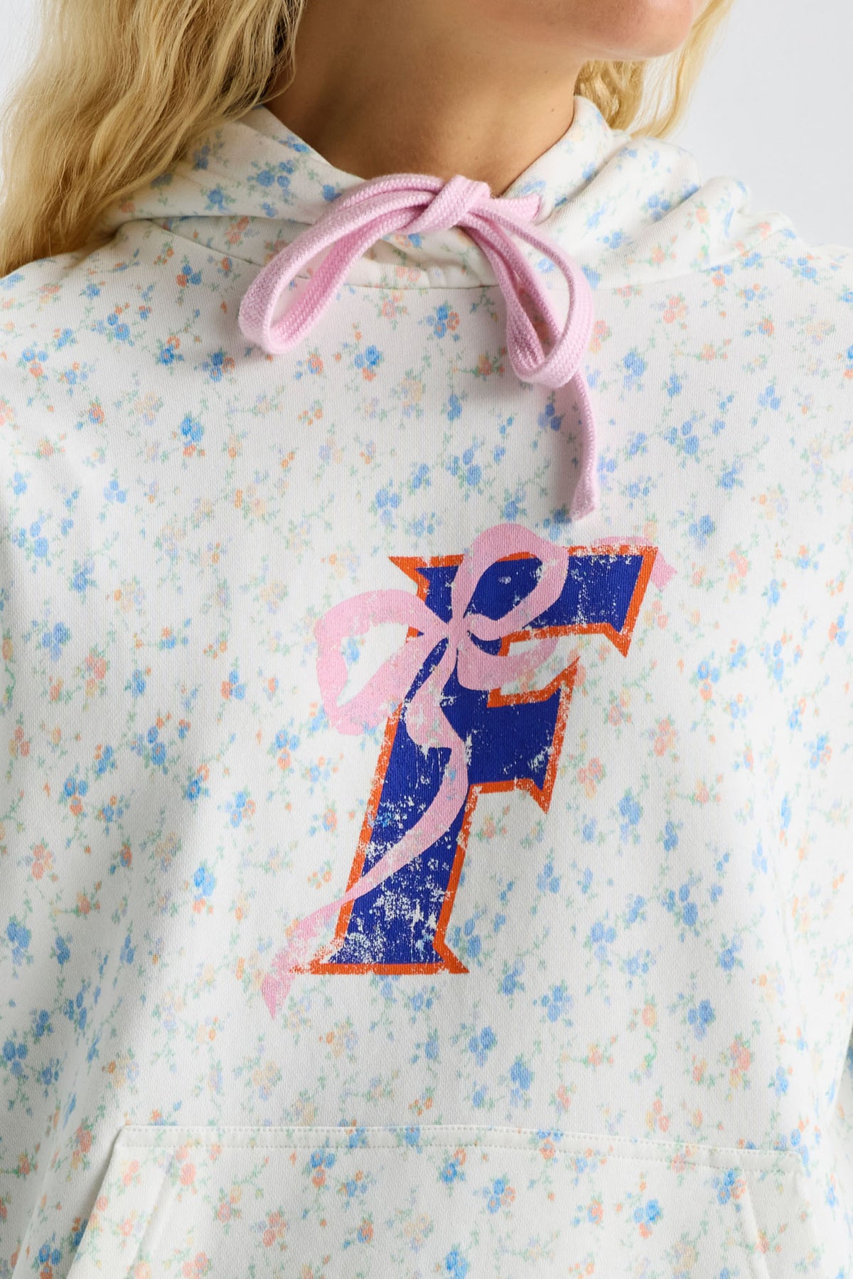 Light blue speckled hoodie with hood drawstring and large navy-and-pink front graphic