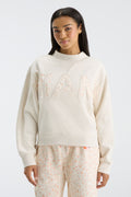 Front view: cream mockneck crew sweatshirt with oversized “FANATICS” floral letters