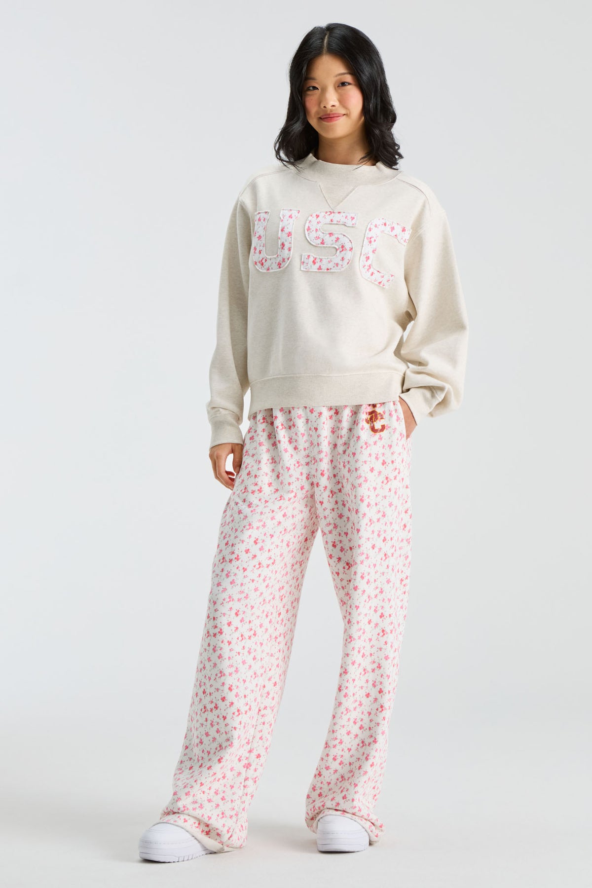 Cream mockneck crew sweatshirt with pink floral “U S C” letters; matching floral pants