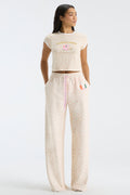 Cream floral-print sweatpants with elastic waistband, drawstring, and wide straight fit