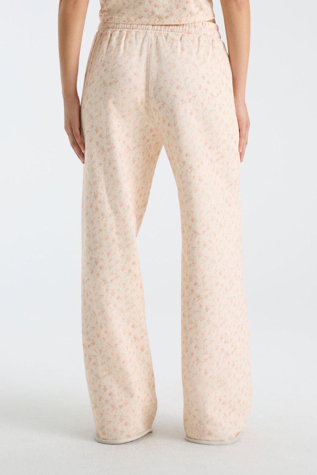 Womenโs wide-leg sweatpants with relaxed straight leg, elastic waistband, and pale floral print