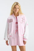 Pink varsity jacket with snap buttons, embroidered letter patch, and ribbed hem