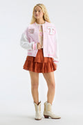 Light pink varsity jacket with Hook 'Em and T patches, button front