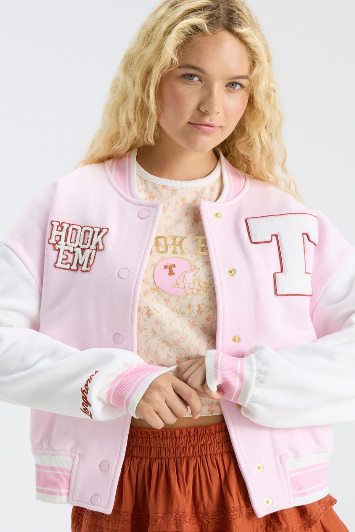 Light pink varsity jacket with T and Hook 'Em patches, ribbed cuffs, button front