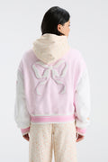 Pink varsity jacket back view with bow emblem and striped rib hem and cuffs