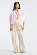 Pink varsity jacket worn over floral top, featuring snap front and striped rib trim