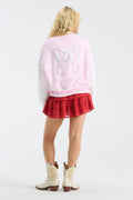 Light pink varsity jacket with large back bow emblem and ribbed striped trim.