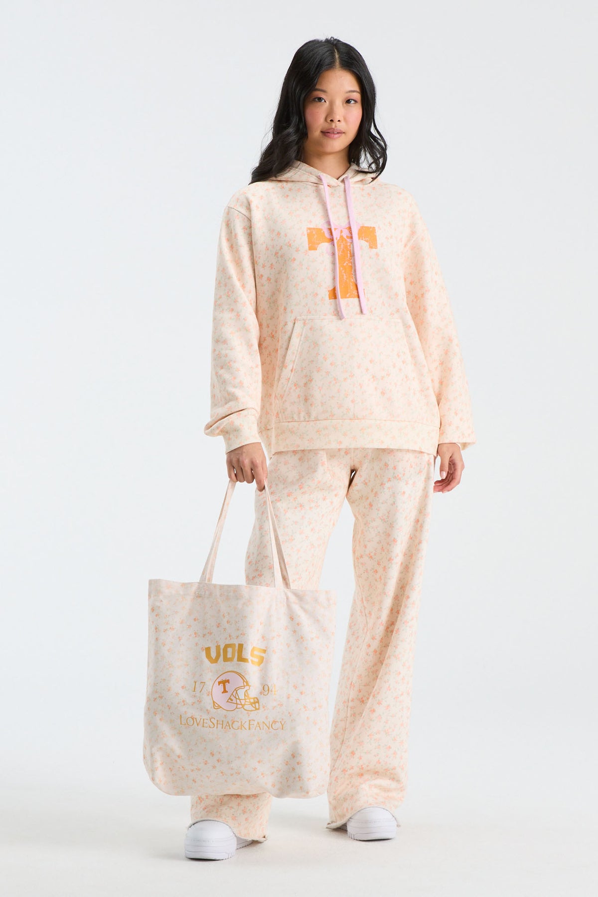 Cream patterned tote bag with printed logo text and top handles