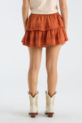 Rust orange ruffle mini skirt with tiered hem and textured fabric.