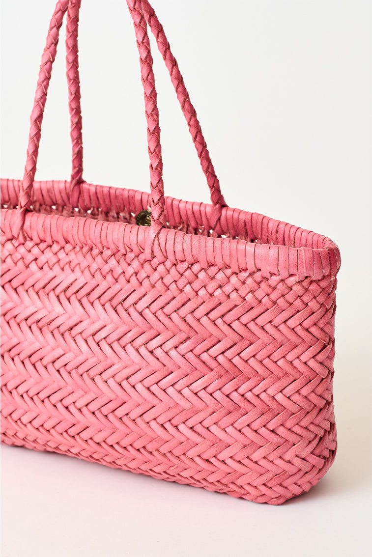 Mini woven tote bag close-up with pink braided handles and open top