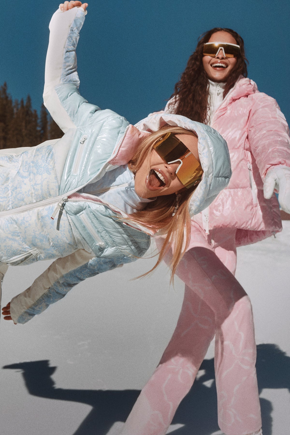 Light pink ski pants with patterned fabric and adjustable waistband tabs