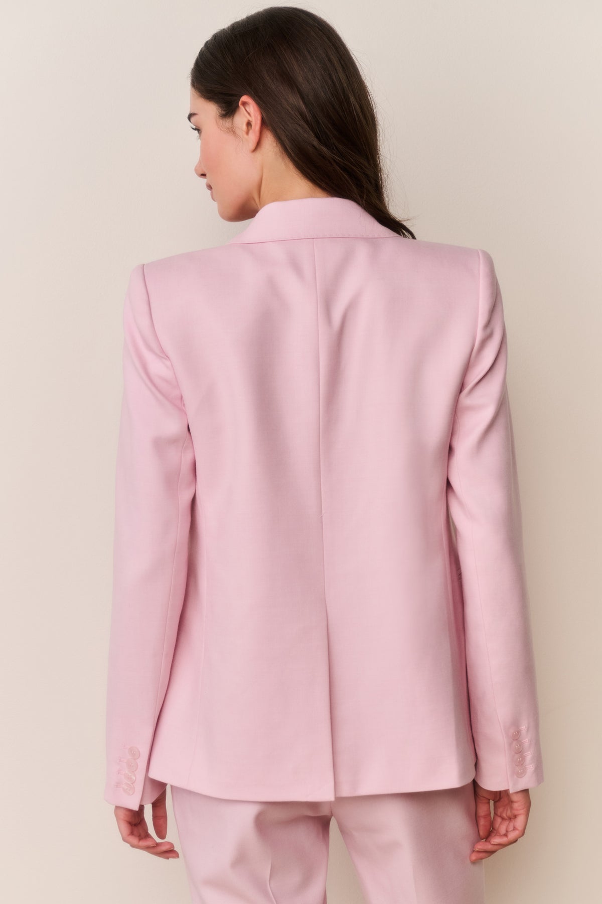 Back view of pink blazer with long sleeves and structured seams