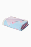 Rolled blanket with blue field and pink star-like blot shapes, stitched edge