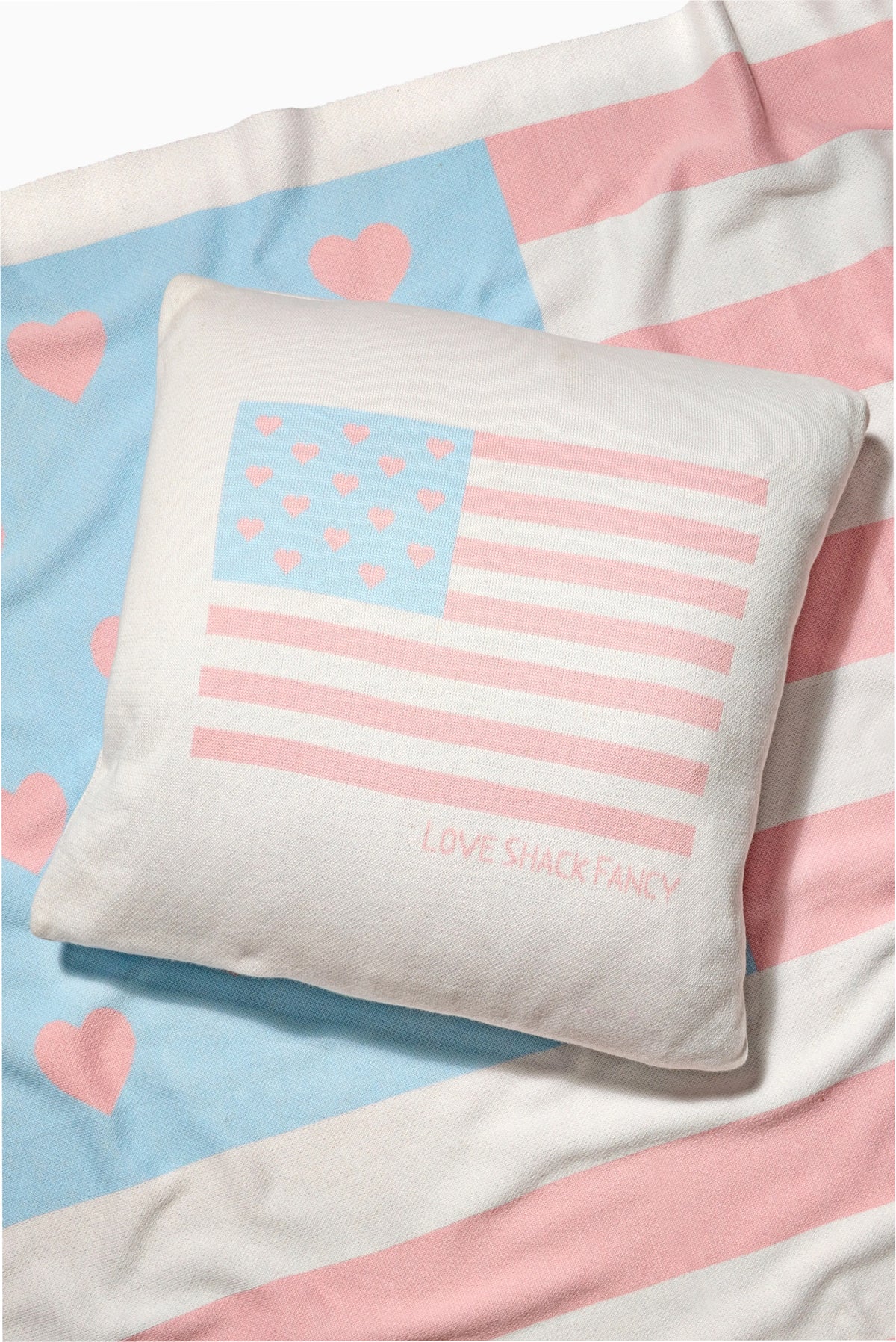 Decorative pillow with faded American flag hearts and pink stripes; LOVE SHACK FANCY