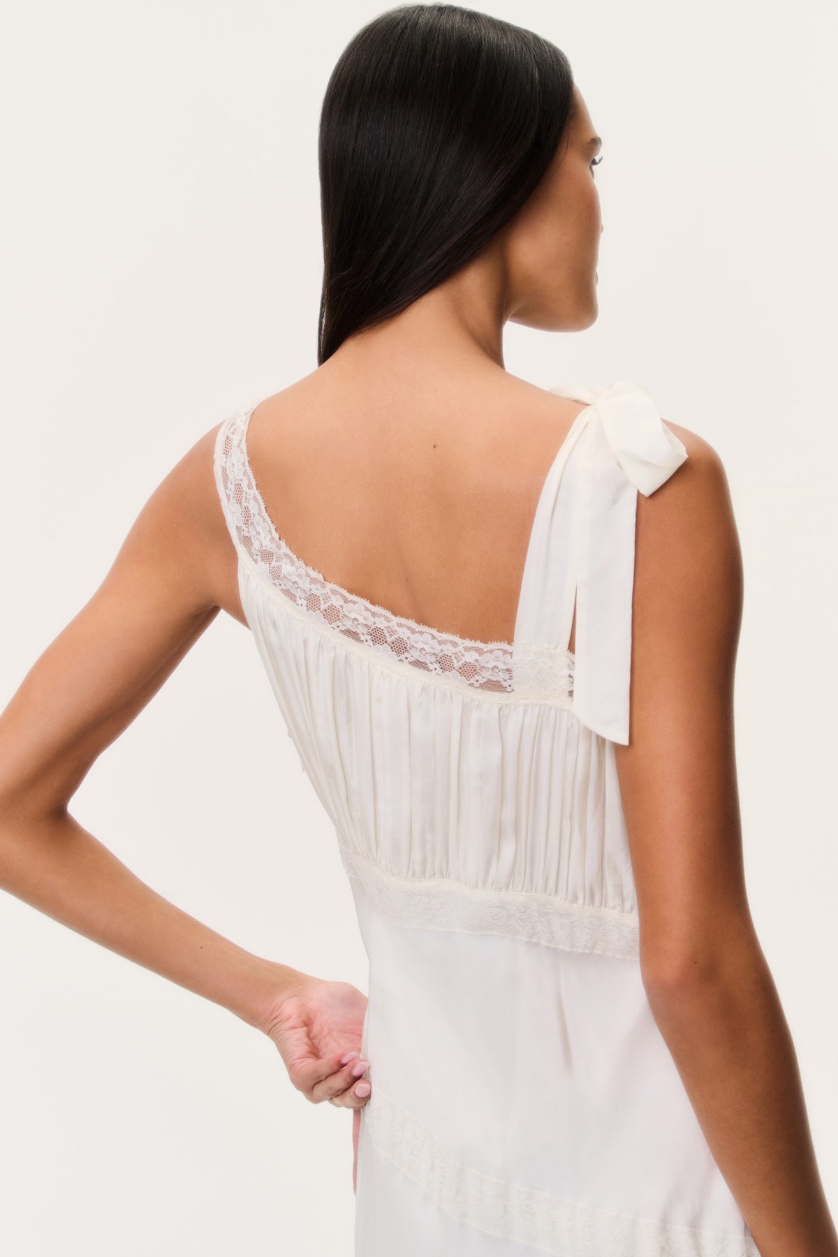 Back view of ivory maxi dress with lace-trimmed straps and bow tie at neckline