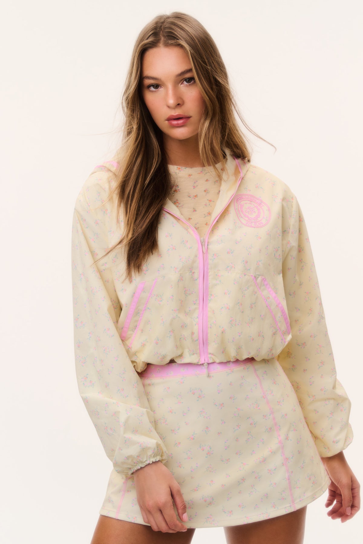 Cream windbreaker hoodie with pink zipper and drawstring hood, front view