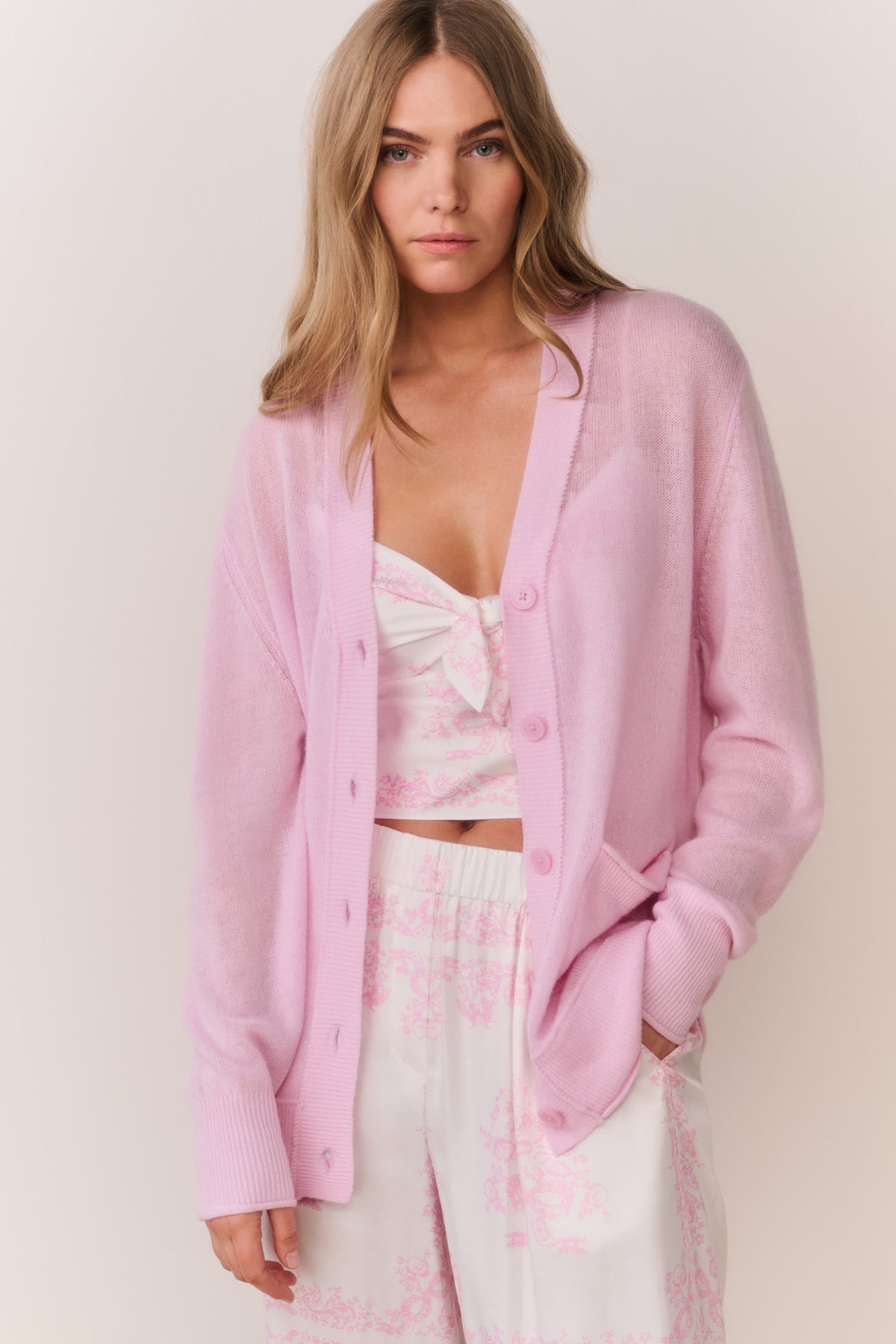 Pink cashmere cardigan layered over floral camisole with open button front