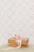 Bow-pattern wallpaper with faded primrose ribbon bows on a pale background