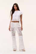 Optic white patchwork lace flared pants, full front view with embroidered patches