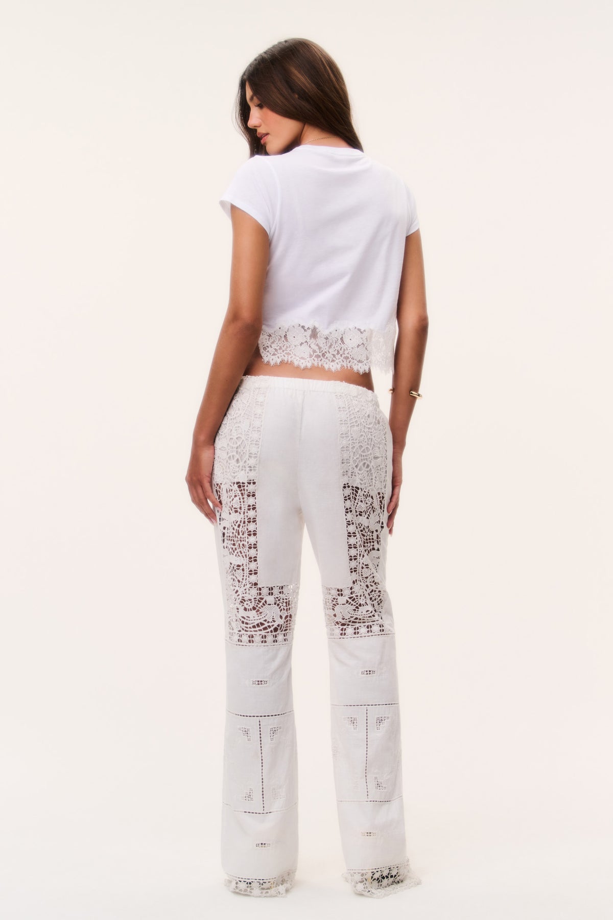 Optic white patchwork lace flared pants, back view with panel embroidery