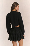 Black ribbed V-neck crop cardigan with button front and long sleeves (side view)