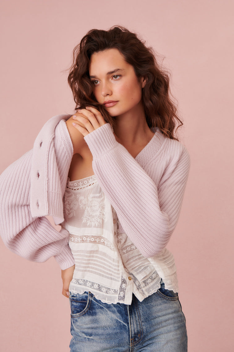 Light pink ribbed cropped cardigan with V-neck and button placket, side view