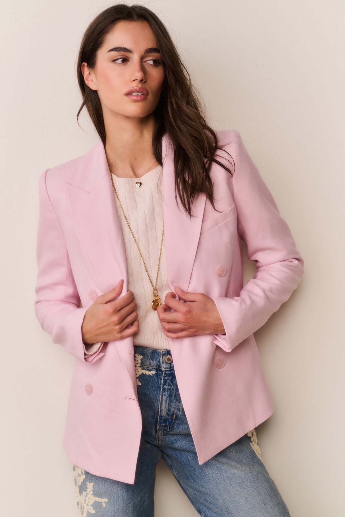 Pink double-breast blazer with bow-tie sleeve detail and long sleeves, worn open
