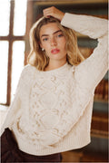 Ivory cable-knit sweater with textured bow front and round crew neckline