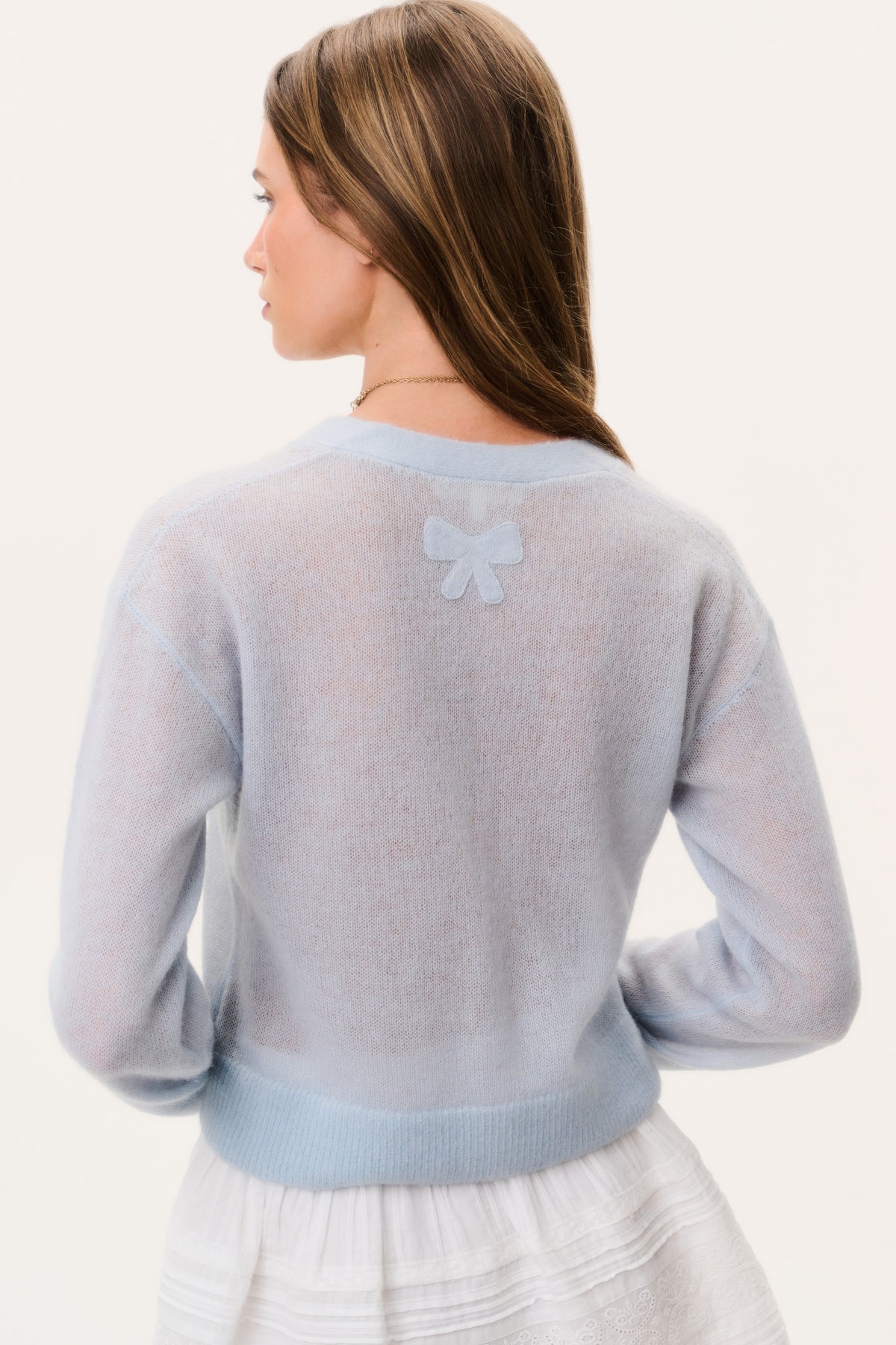 Light blue sheer alpaca cardigan back view with small bow applique