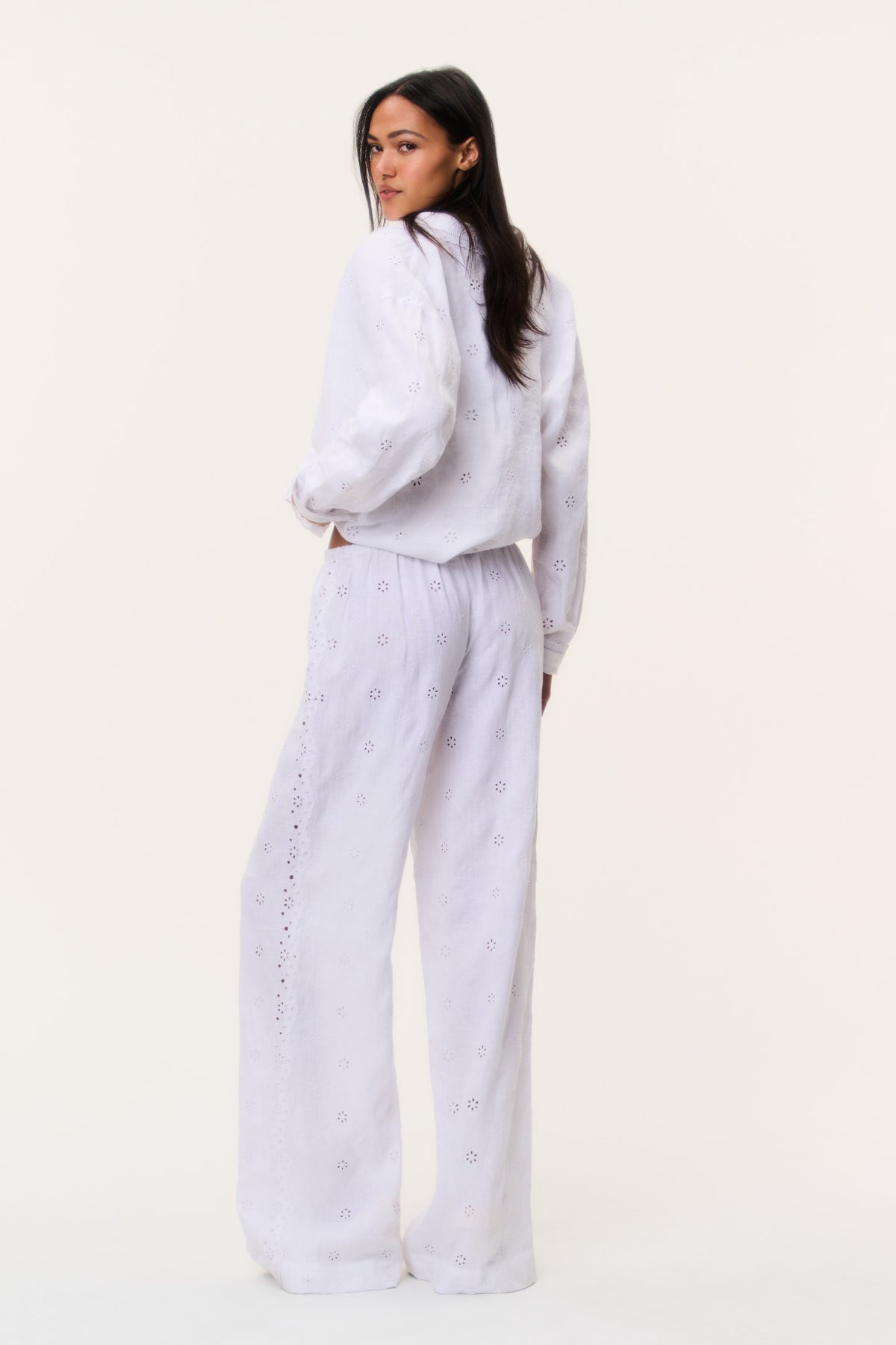 Optic white eyelet linen pants, side view of high waist and wide straight legs