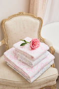 Cotton bath towel, pink and white floral print, folded stack with flower on top