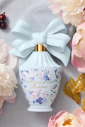 Light blue decorative perfume bottle with light blue bow and blue floral label