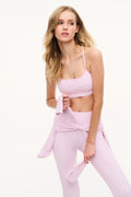 Light mauve bow-print sports bra with thin straps, front view