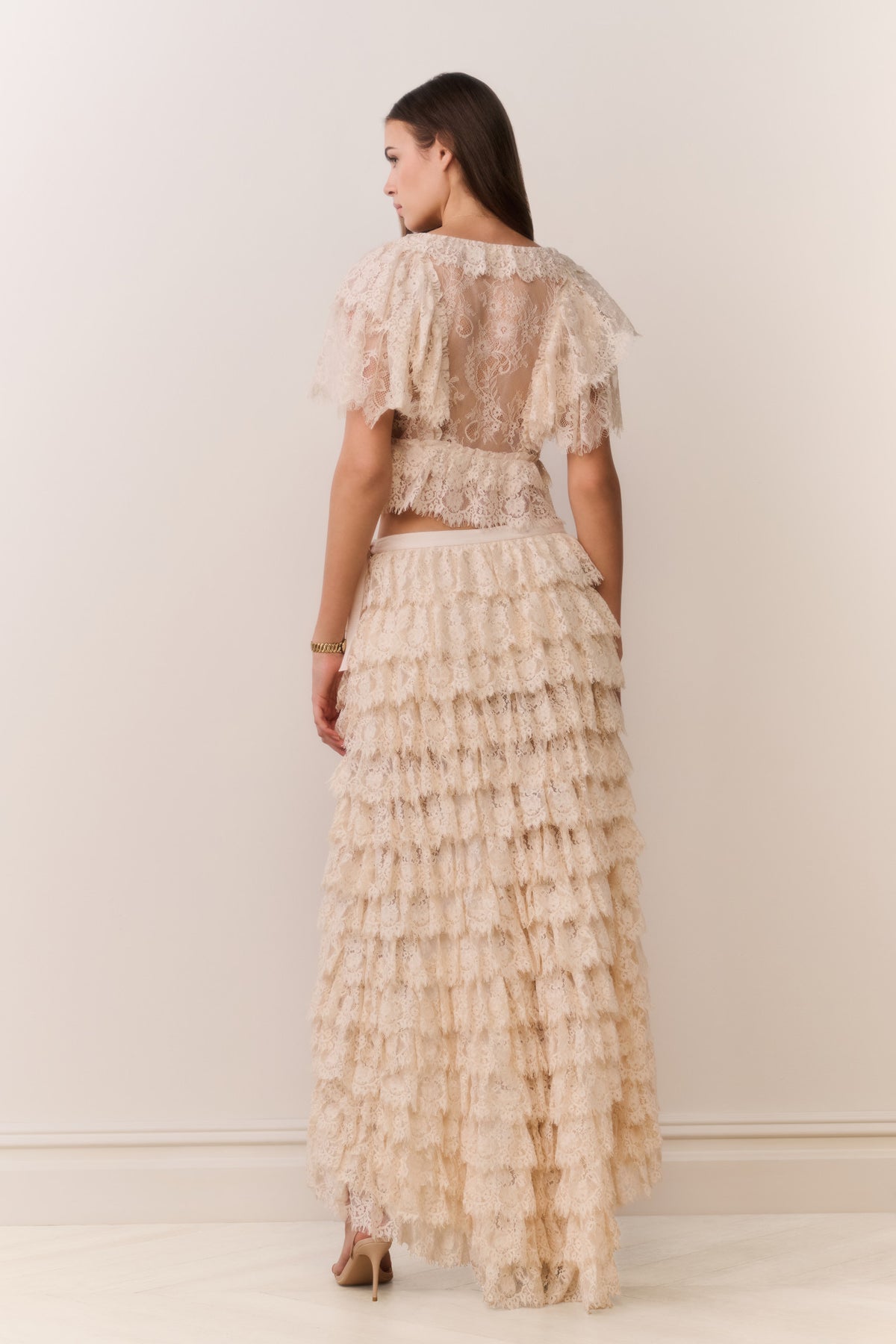 Back view of ivory lace ruffle high-low skirt with tiered ruffles and lace texture