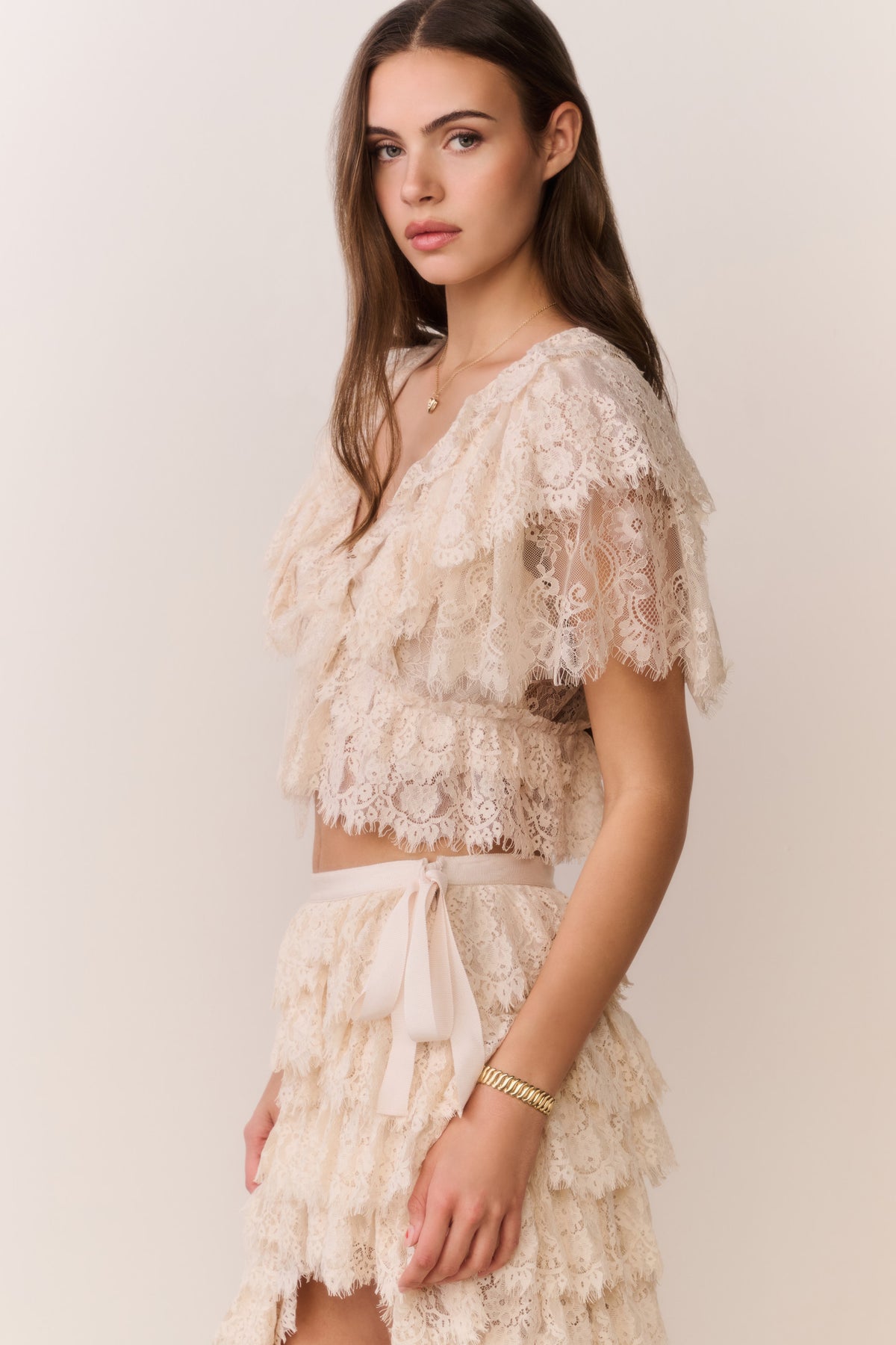 Ivory lace ruffle crop top with detailed lace sleeves and tiered hem